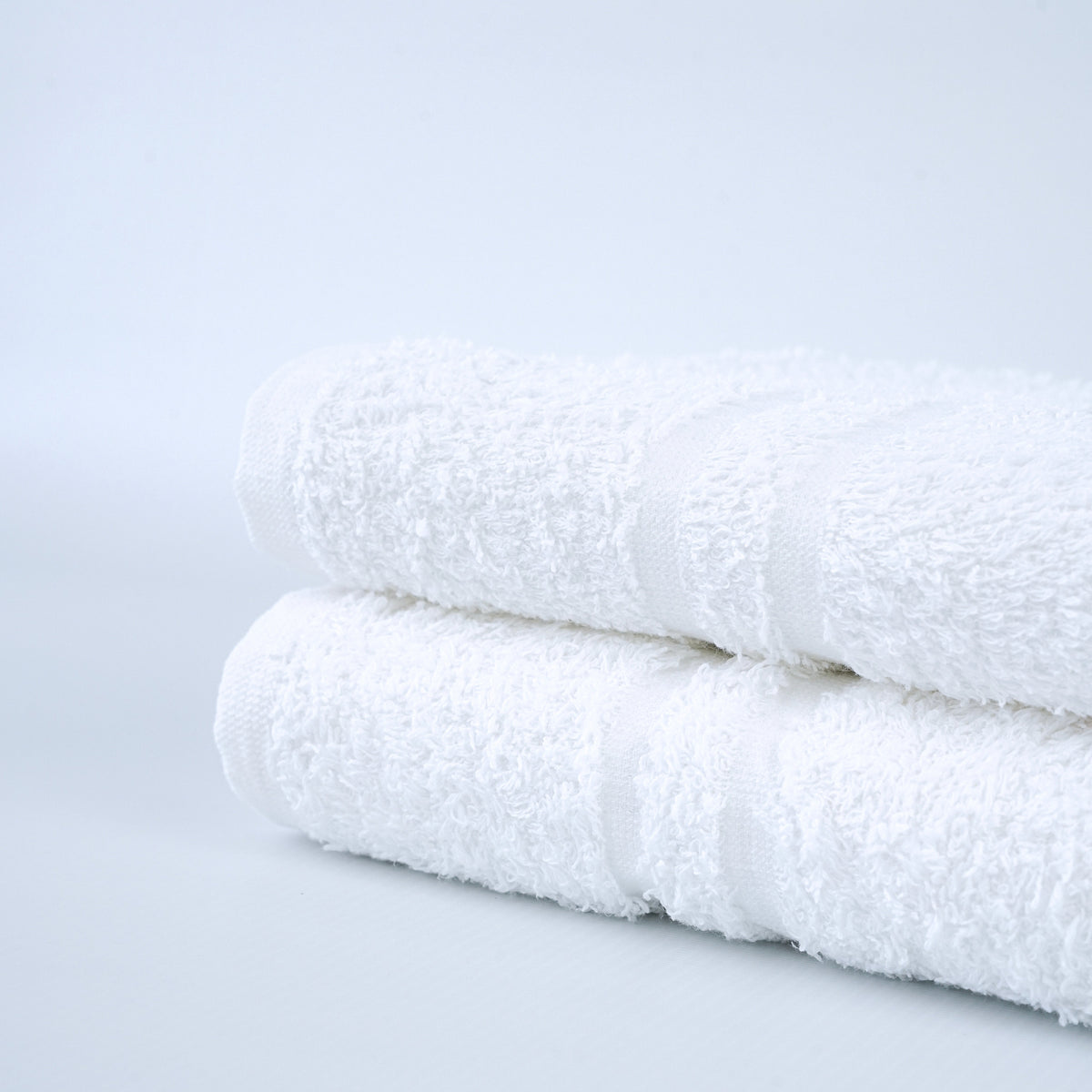 Platinum white ring-spun blended bath towels with double cam border. Manufacturer family detail photograph.