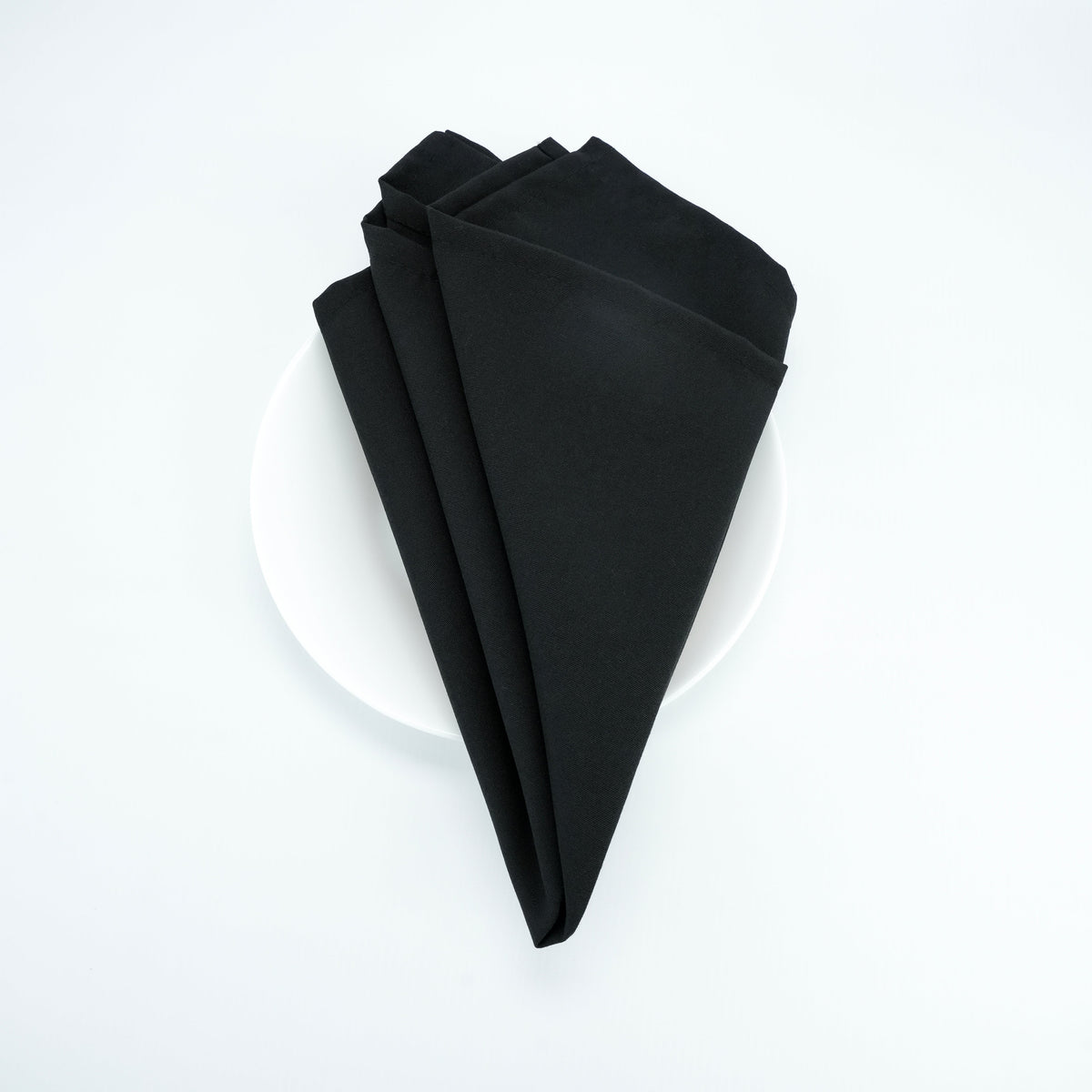 Black 20 x 20 spun polyester napkin, folded presentation. Napkins only; plate is a photo prop.