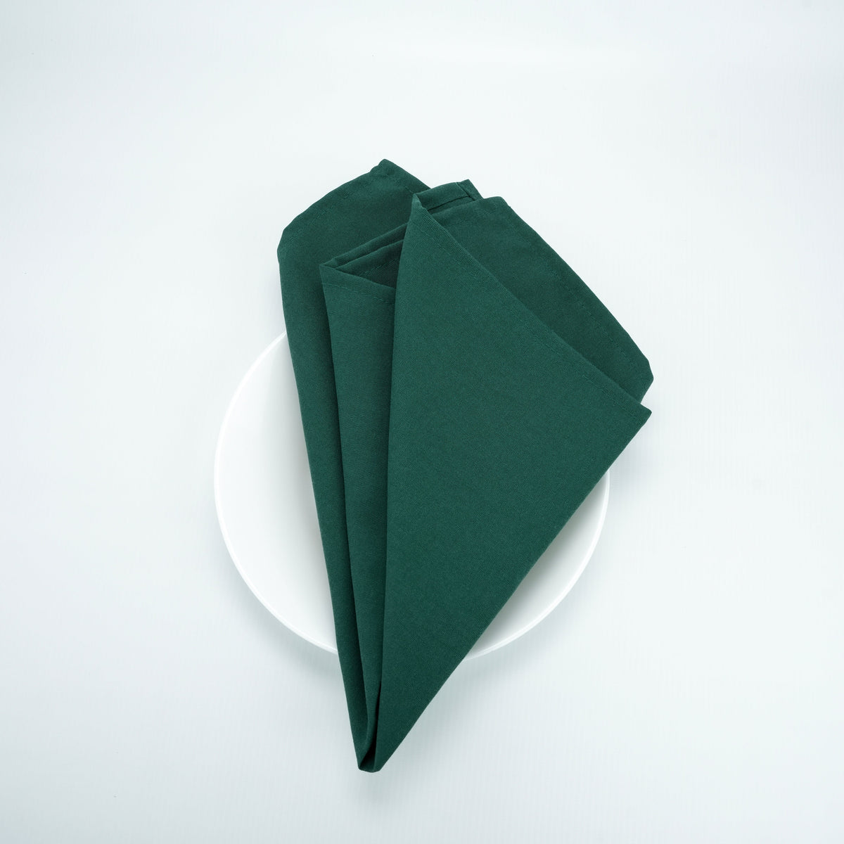 Green 20x20 spun polyester napkin. Plate shown for presentation; plate is not included.