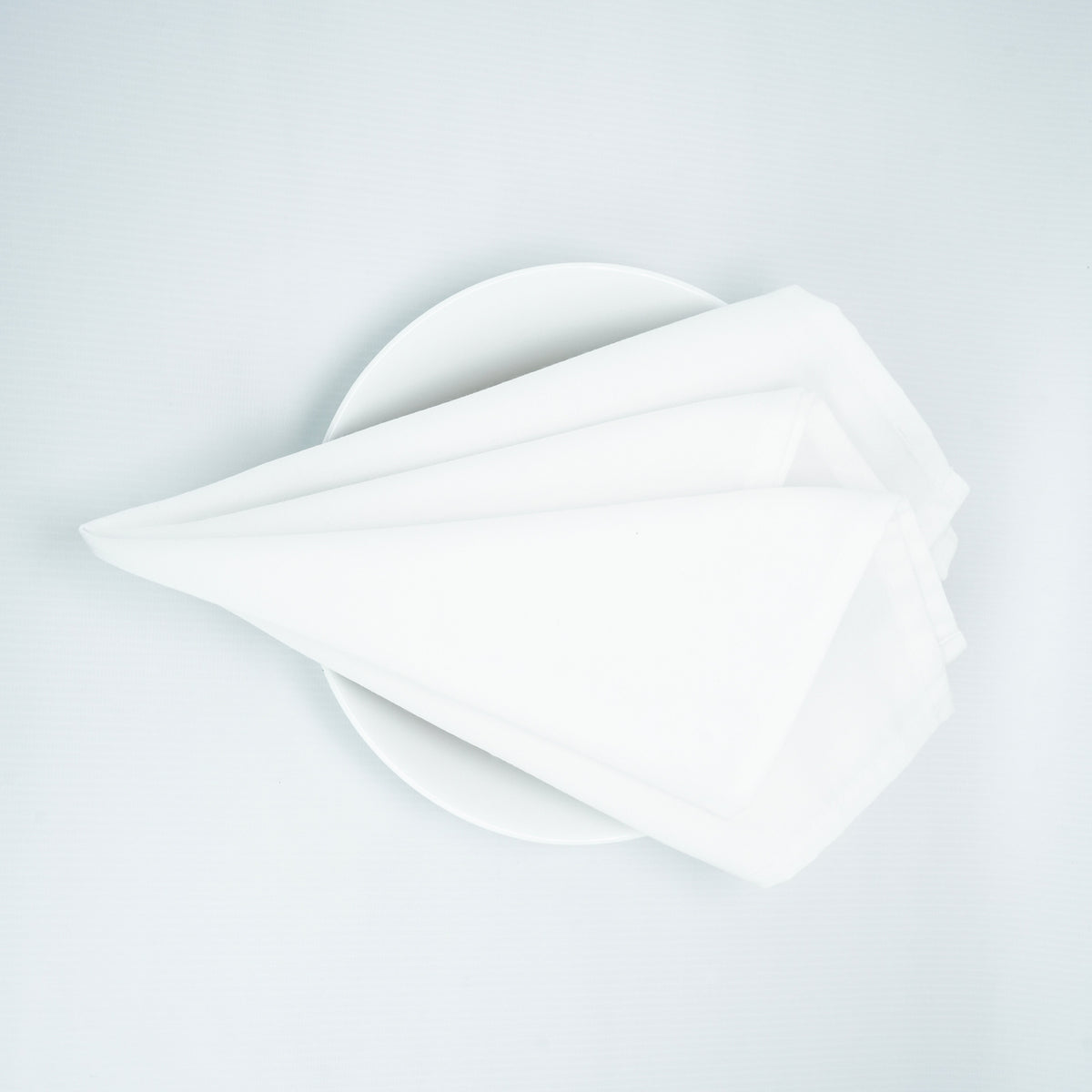 White 20 x 20 spun polyester napkin, folded presentation. Napkins only; plate is a photo prop.